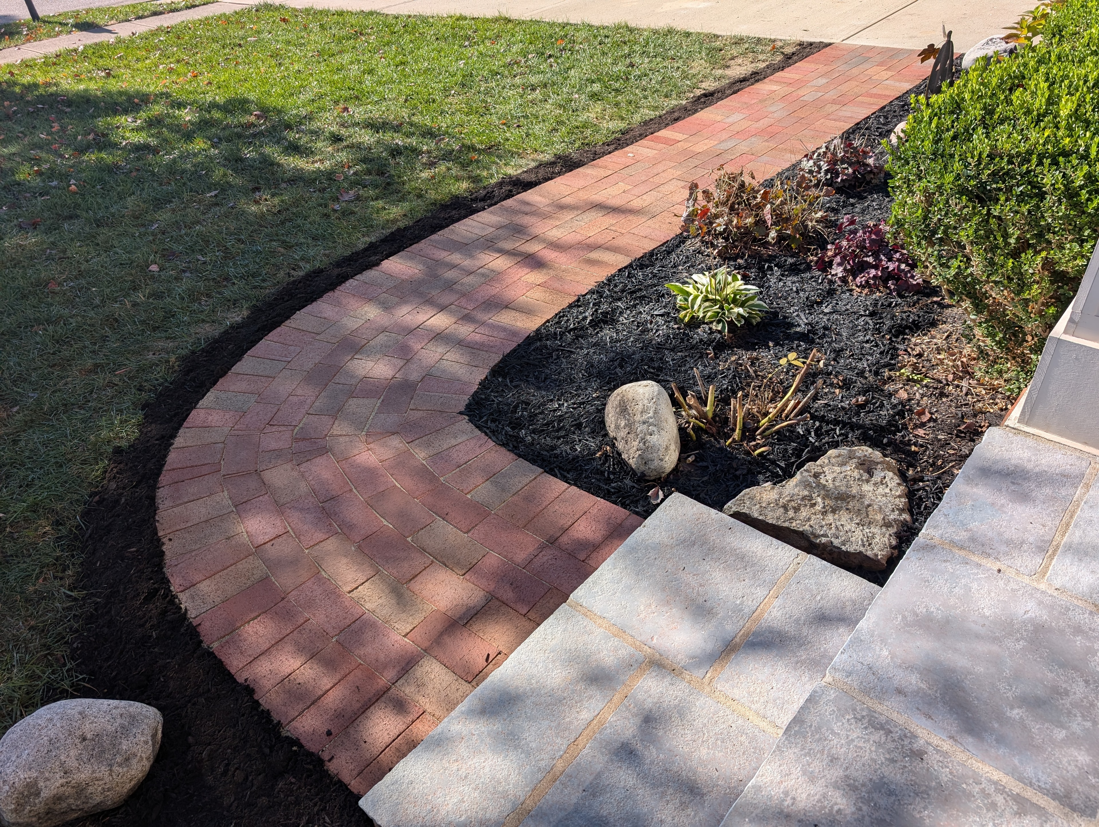 Curved paver walkway with garden beds by Mark Monnette Masonry